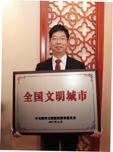 图为宜兴市委书记沈建在京领取全国文明城市奖牌。
