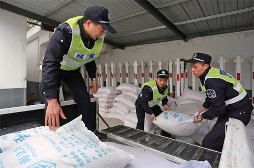 图为昨日，市城管部门工作人员正在搬运工业盐。