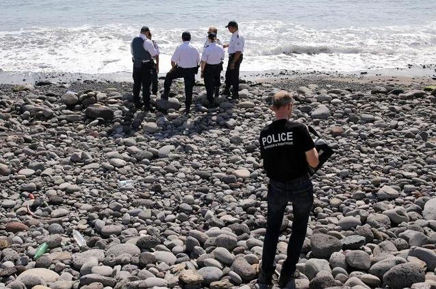 法属留尼汪首府圣但尼附近的一处海滩上，警员正在现场对金属残片进行勘察