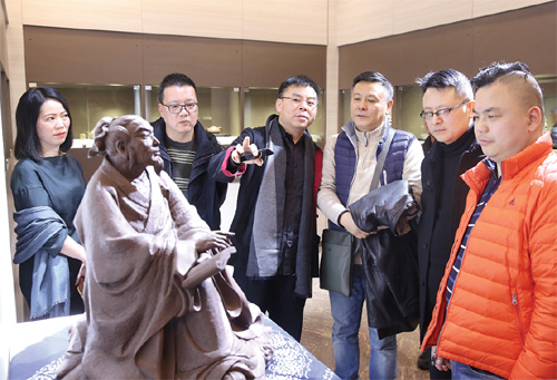 图为1月27日，史小明（右四）向上海紫砂爱好者介绍紫砂雕塑《茶圣陆羽》的创作经过。